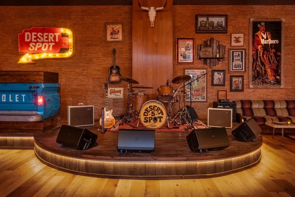 Warm, Western-themed bar with illuminated stage and pickup truck.
