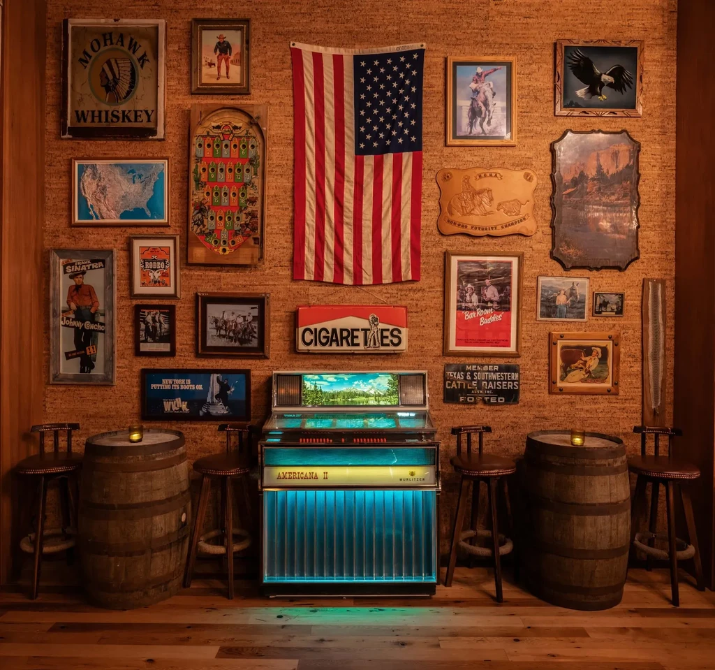 Antique Wurlitzer jukebox with blue-green light in rustic, Western-themed interior.