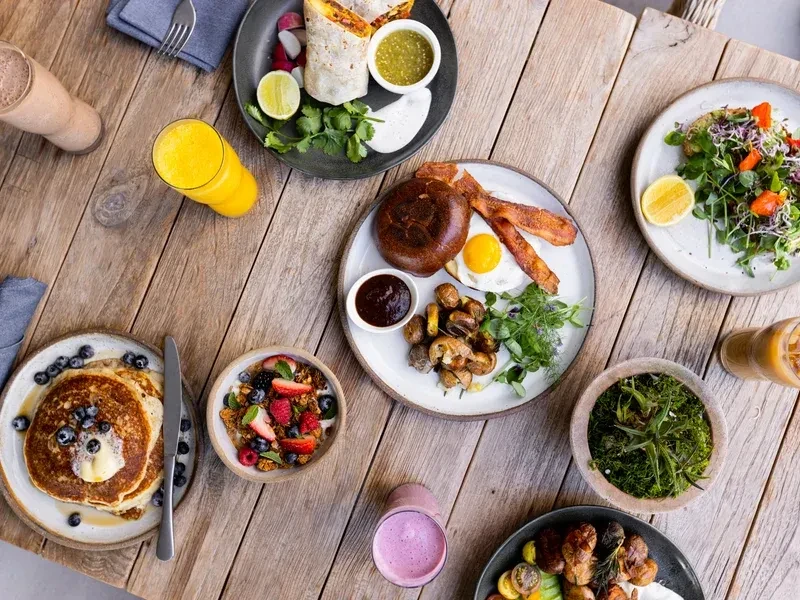 Overhead: Rustic table laden with diverse breakfast and brunch items.