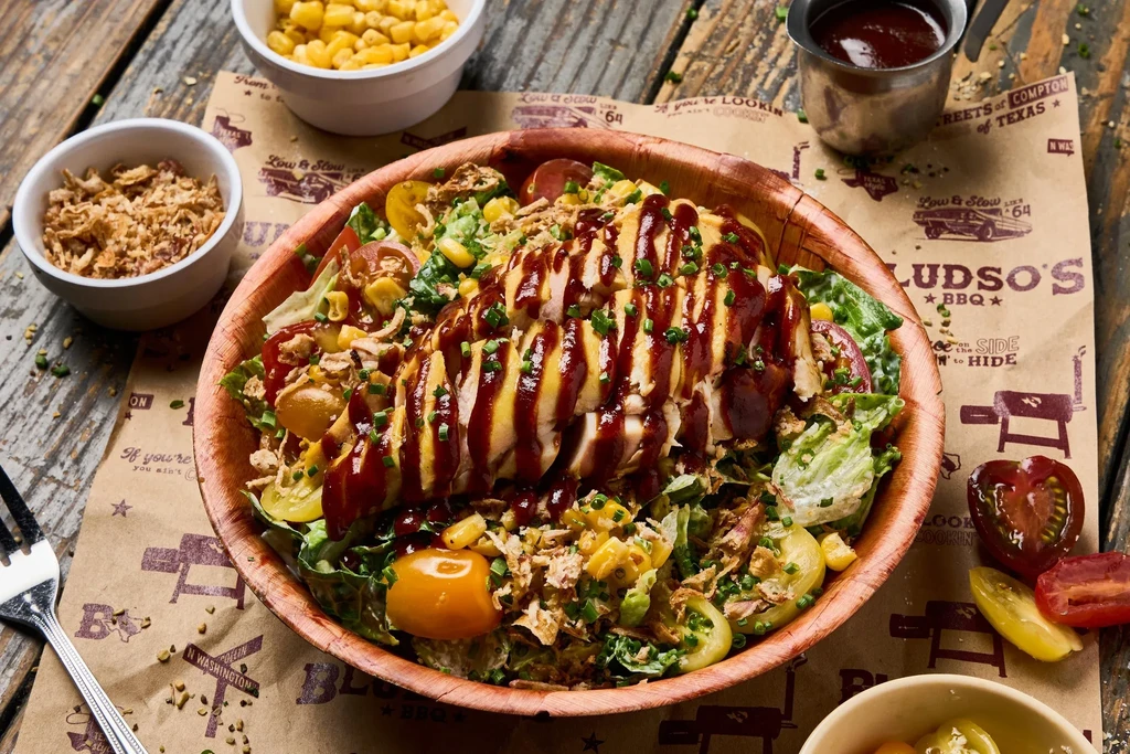 A large Bludso's BBQ chicken salad with mixed greens and vegetables.