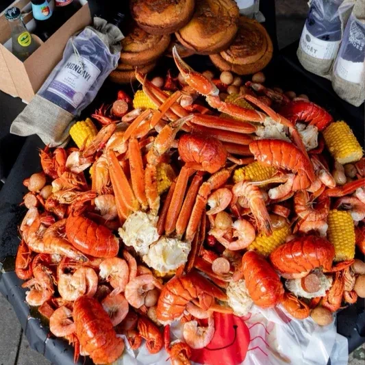 Overflowing seafood boil with crab, shrimp, lobster, corn, and sausage.