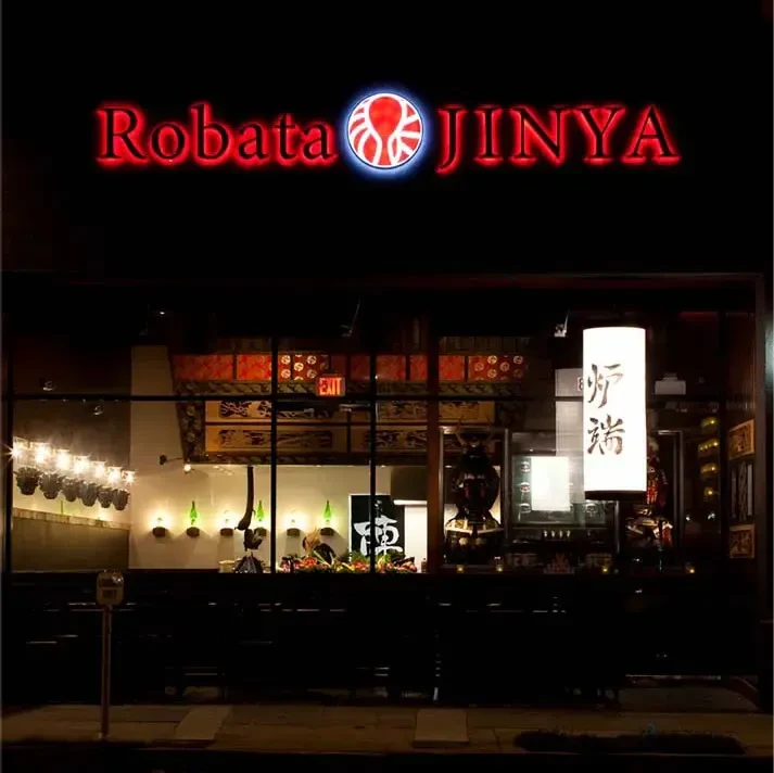 Exterior of Robata JINYA Japanese restaurant at night, red neon octopus sign.