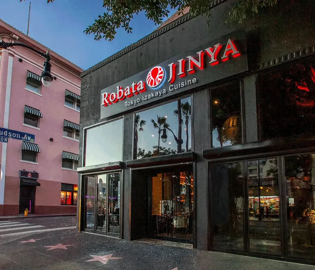 Robata JINYA restaurant exterior on Hollywood Walk of Fame at dusk.