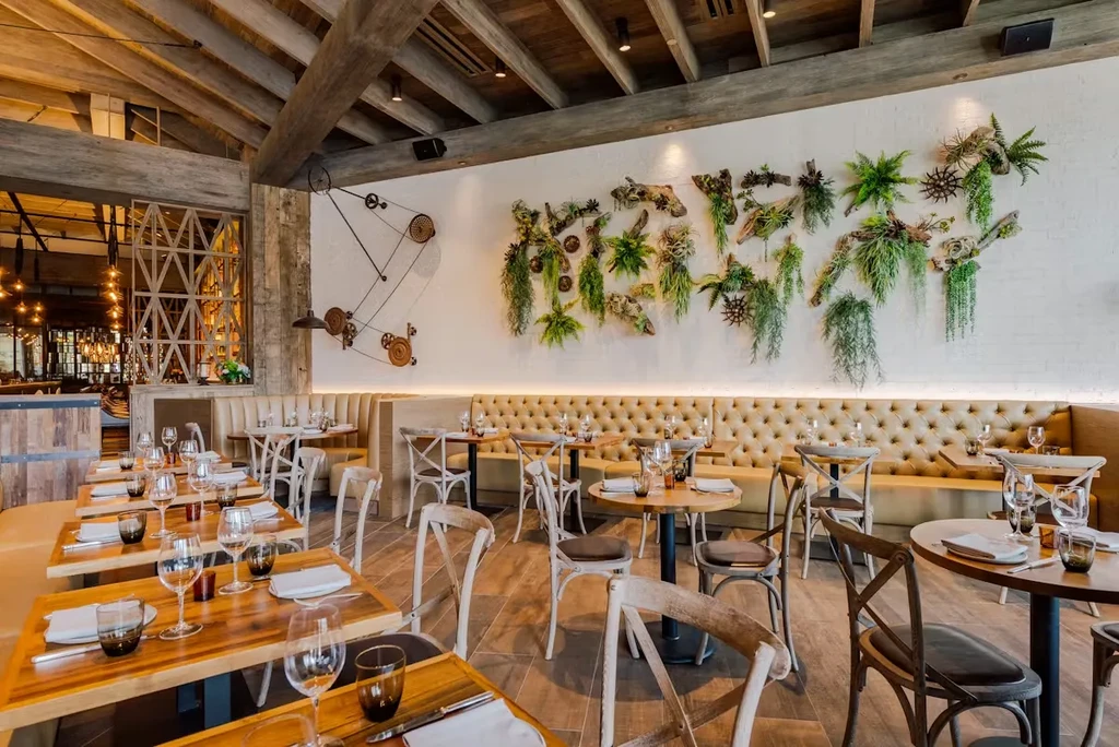 Empty, elegant modern restaurant interior with exposed beams and vertical garden.
