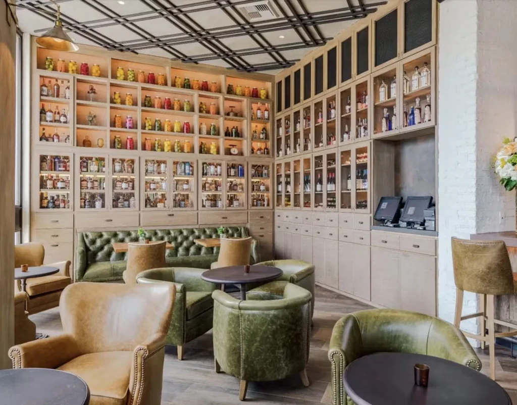 Stylish bar interior with extensive bottle display and leather seating.
