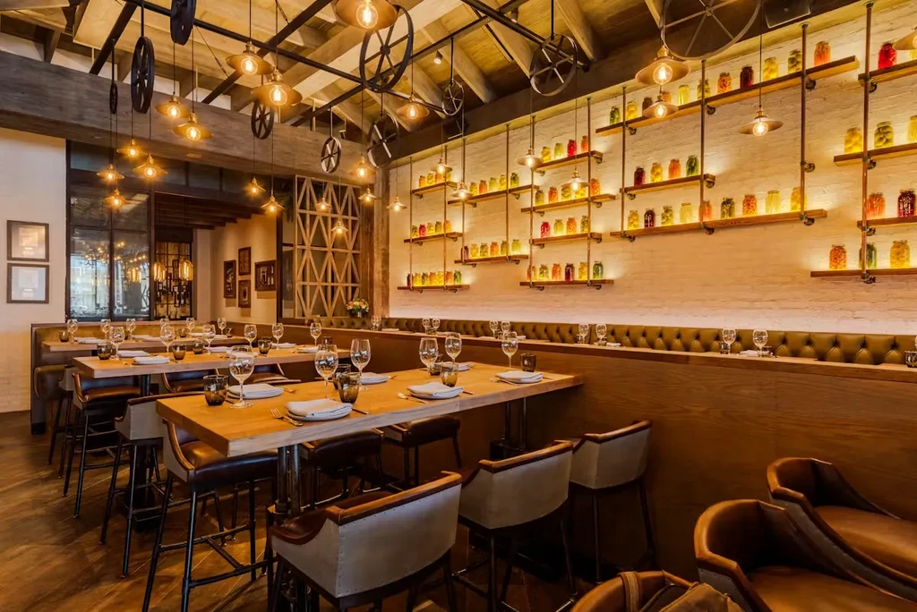 Rustic-industrial restaurant interior with unique pendant lights and colorful jars.
