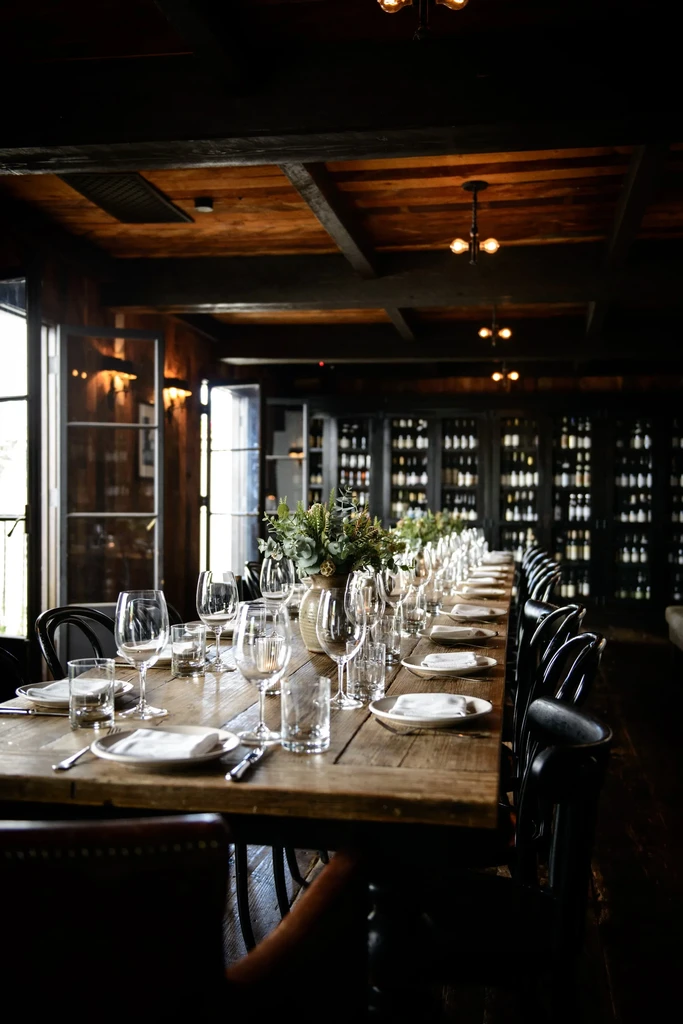 Rustic wooden dining table set in a sophisticated restaurant interior.