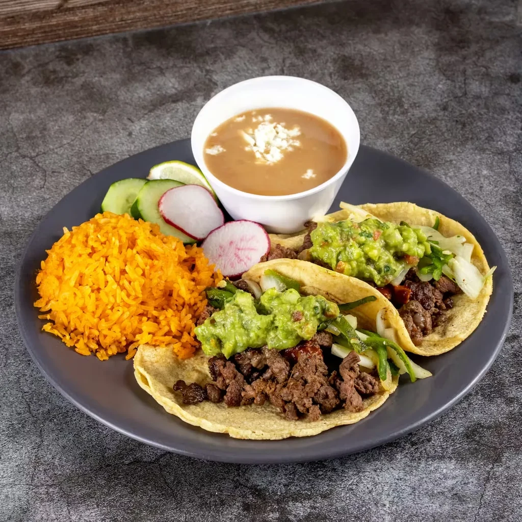 Well-arranged plate of Mexican food: tacos, Spanish rice, and beans.