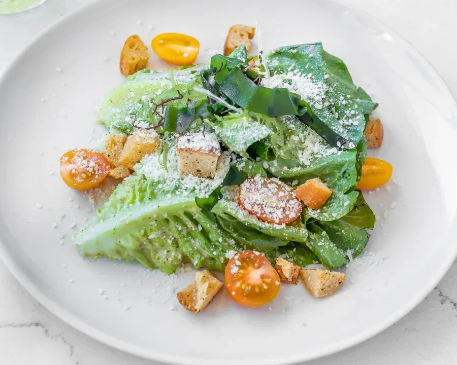 Fresh salad with lettuce, grated cheese, croutons, and cherry tomatoes.