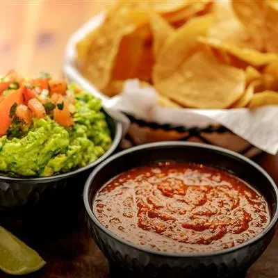 Mexican chunky salsa, guacamole with tomatoes, lime, tortilla chips.