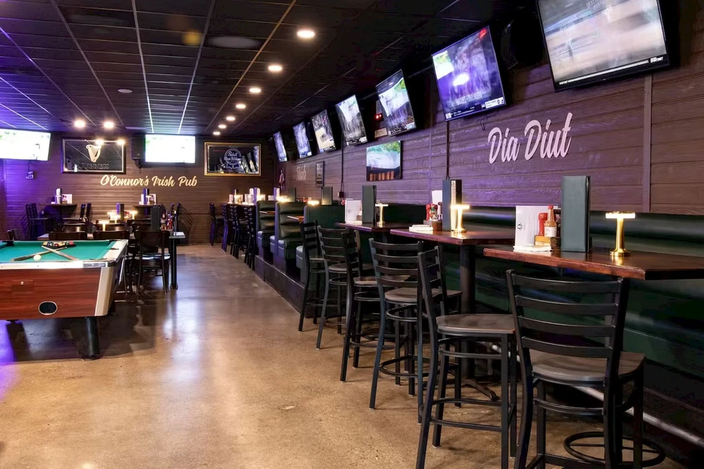 O'Connor's Irish Pub interior: dark wood, TVs, pool table, empty booths.