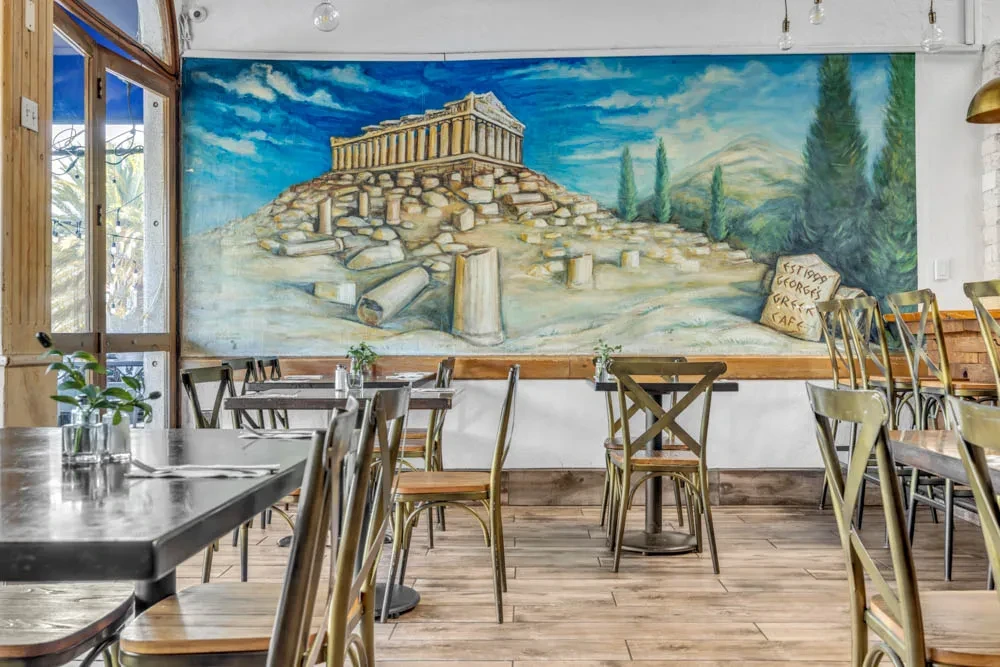 George's Greek Cafe dining area with a large Parthenon mural.
