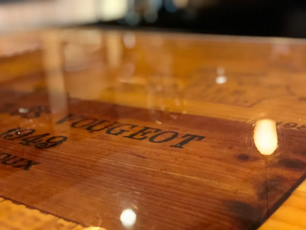 Close-up of reflective warm wood with "VOUGEOT 1949" text.