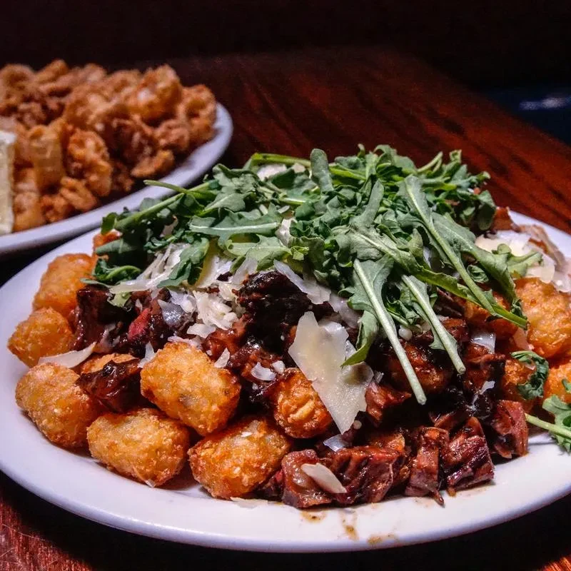Golden tater tots, diced steak, arugula, and shaved white cheese.