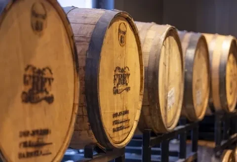 Row of wooden aging barrels, "FREY" clearly branded on the front.