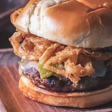 Char-grilled beef burger with melted cheese, jalapeños, and crispy onion rings.