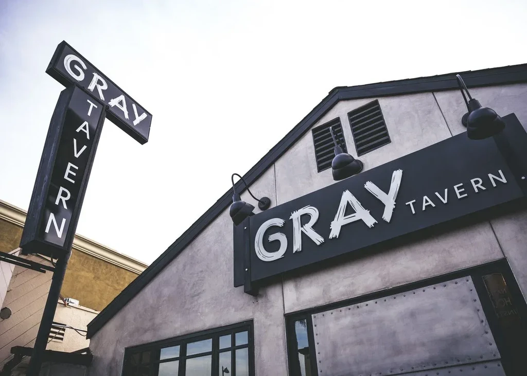 Modern Gray Tavern building exterior with two prominent signs.