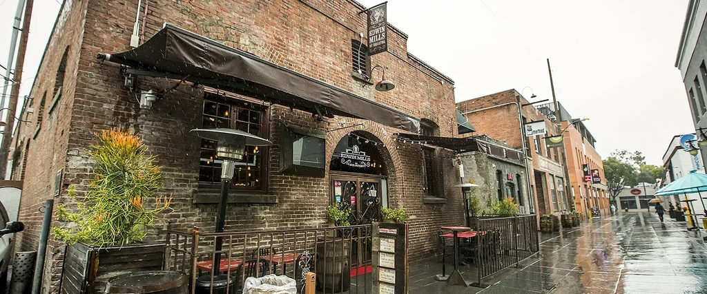 Brick Edwin Mills restaurant facade on a wet, overcast day.