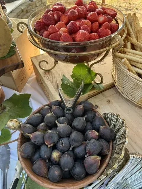 Strawberries, figs, and breadsticks on a rustic wooden table.