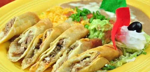 Yellow plate of rolled tacos, rice, beans, and guacamole.