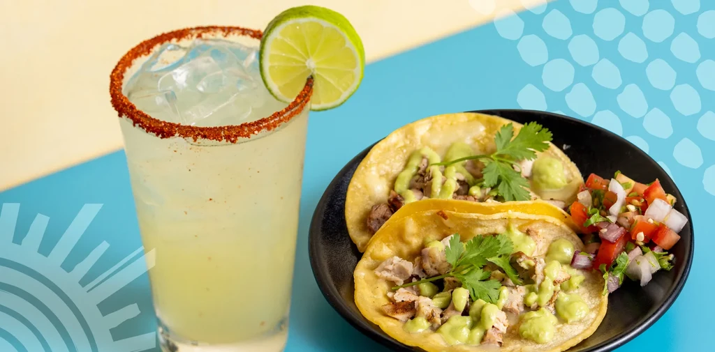 Tacos with green sauce, pico de gallo, and a spiced lime drink.