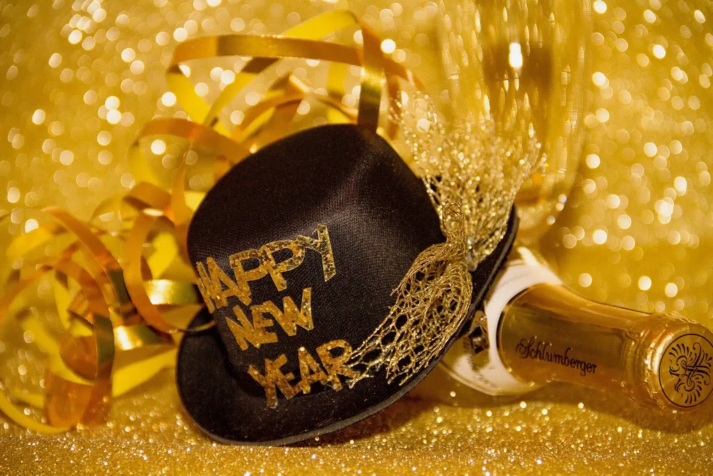 Glittery "HAPPY NEW YEAR" hat and Schlumberger champagne bottle.