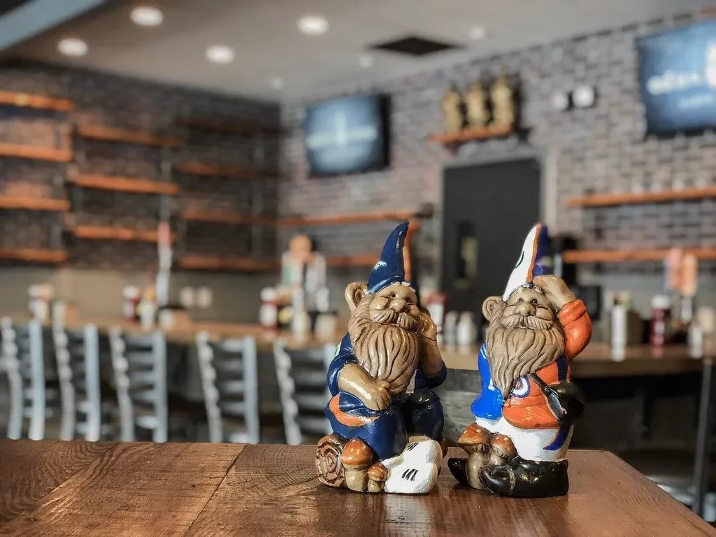 Two sports-themed gnomes with beards sit on a restaurant table.