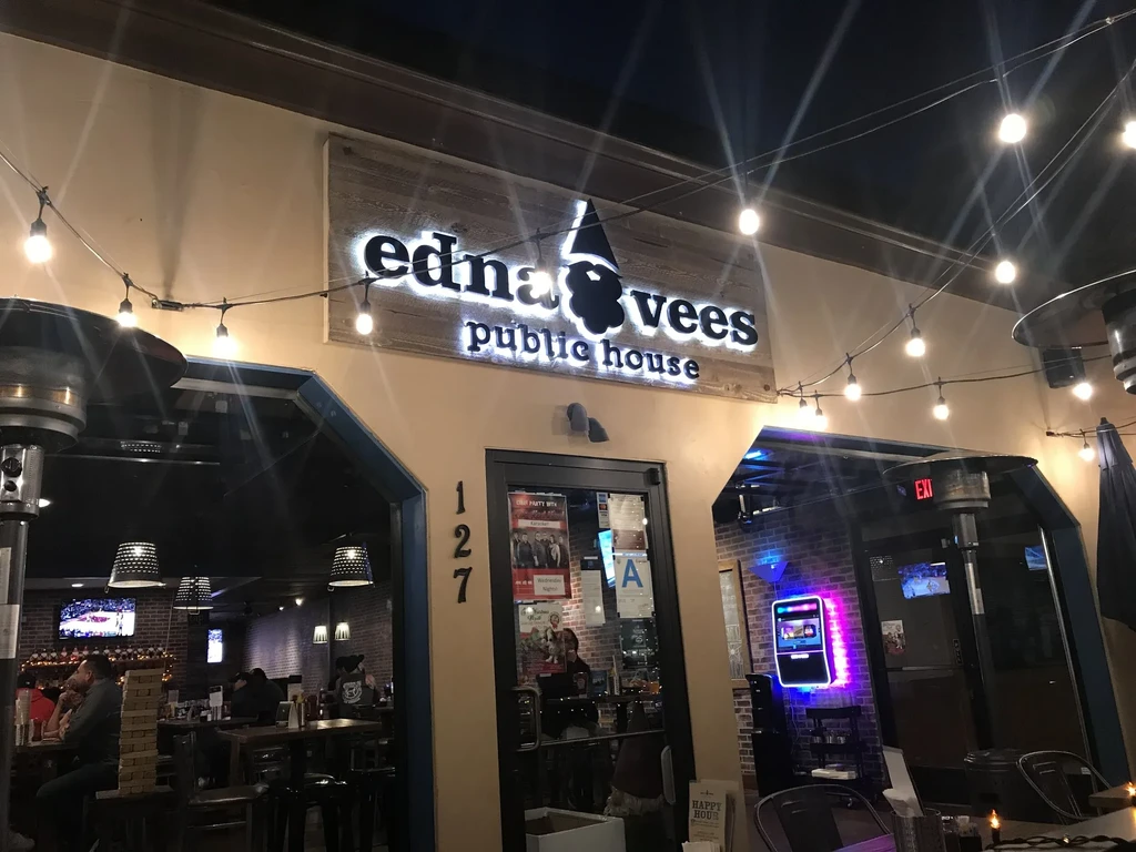 Entrance to edna & vees public house with gnome sign, string lights.