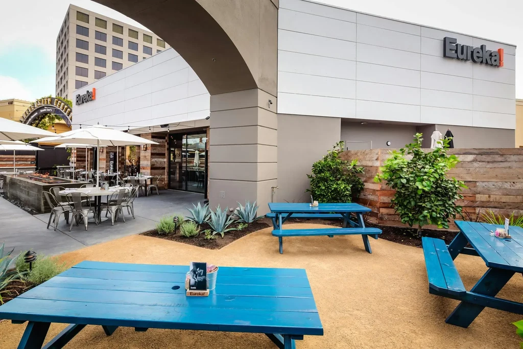 Eureka! restaurant patio with diverse seating, fire pit, and landscaping.