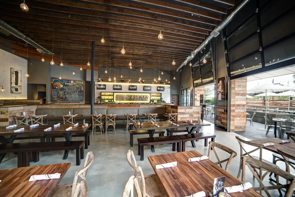Empty modern restaurant and bar interior opening to a patio.