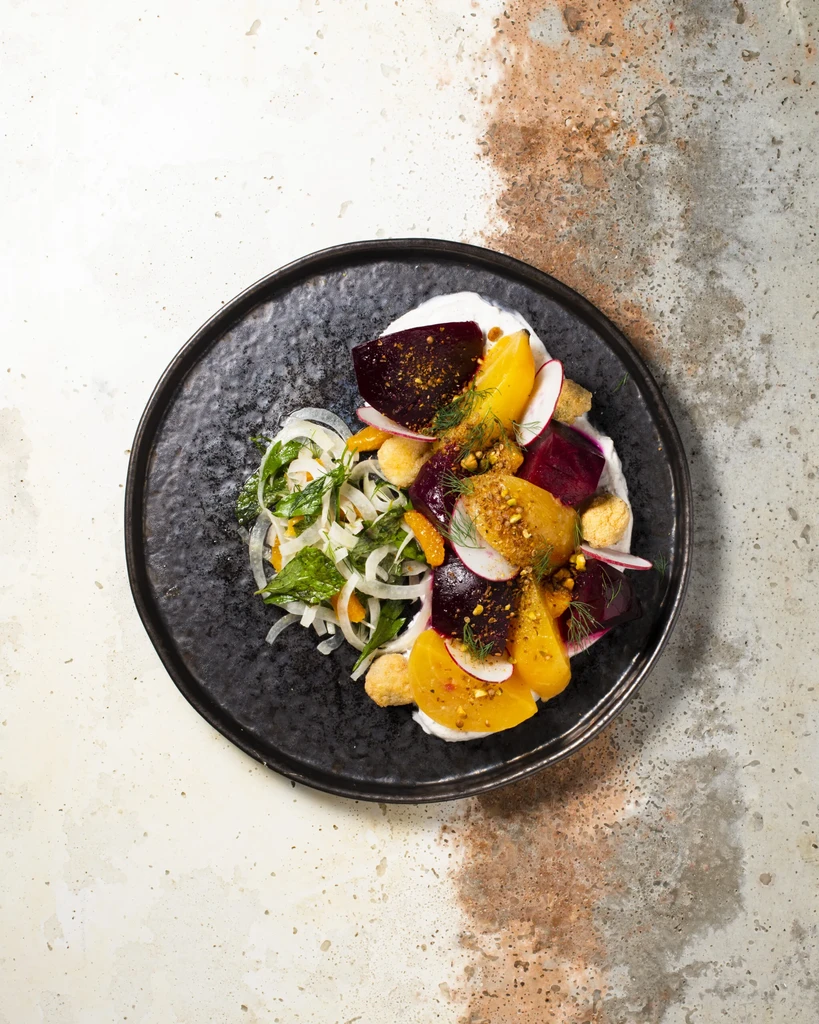 Meticulously arranged colorful beet, radish, and herb salad.