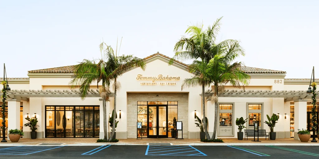 Facade of Tommy Bahama restaurant, bar, and store with palm trees.