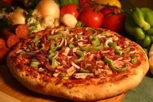 Freshly baked pizza topped with meat, peppers, onions, and cheese.