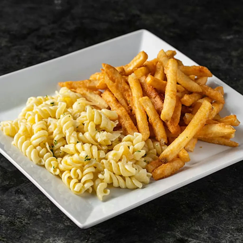 White plate features spiral pasta with herbs and crispy french fries.