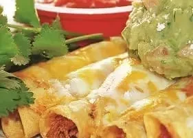 Enchiladas with melted cheese, guacamole, cilantro, and red salsa.