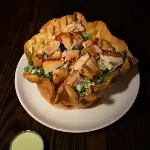 Grilled chicken Caesar salad in a crispy fried tortilla bowl.