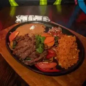 Tex-Mex fajita-style meal in a black cast iron skillet.