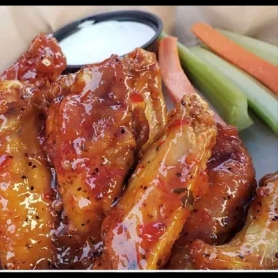 Plump chicken wings in red-orange sauce, with ranch, carrots, and celery.