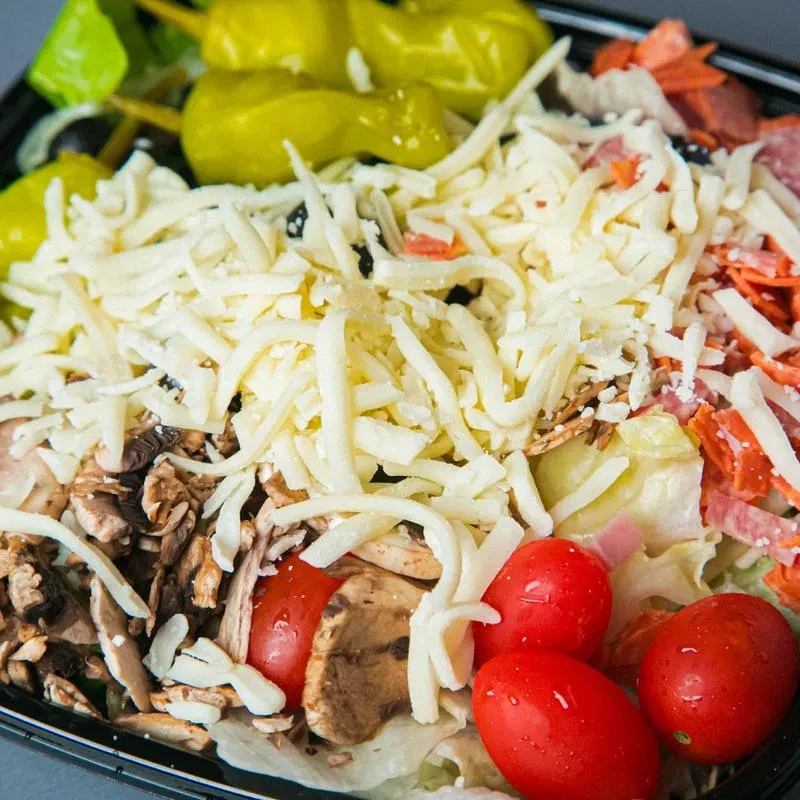 Large takeout salad with cheese, pepperoni, lettuce, tomatoes, mushrooms, olives.