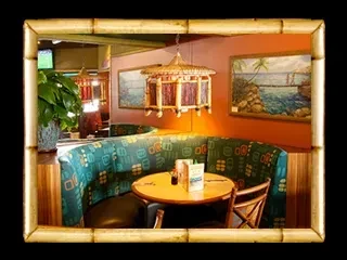 Tropical restaurant booth with teal seating and pagoda light fixture.