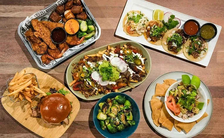 Overhead view: a wooden table displaying a varied menu of food.