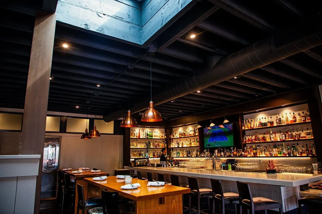 Warmly lit upscale bar and restaurant dining area.