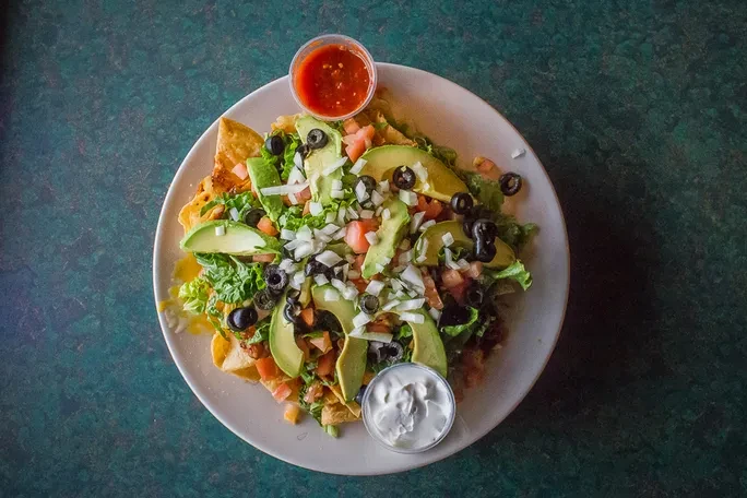 Overhead view of a large plate of loaded nachos.