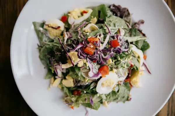 Close-up, top-down view of a vibrant salad with hard-boiled eggs.