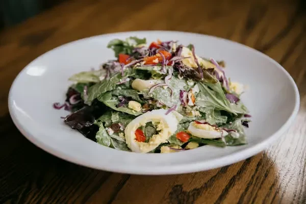 Vibrant salad with deviled eggs, purple cabbage, red bell peppers.