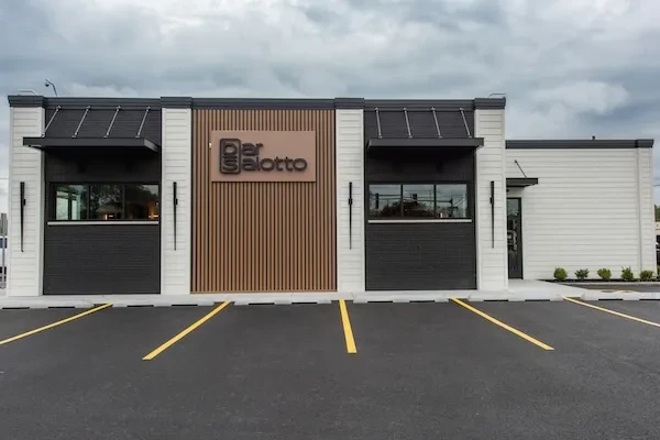 Exterior of modern restaurant "Bar Salotto" with wooden slats.
