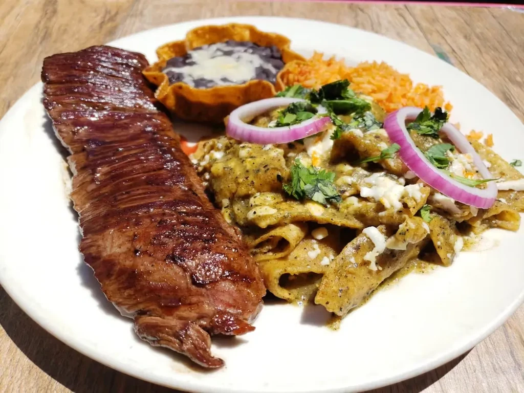 High-angle close-up of a Mexican steak and chilaquiles meal.