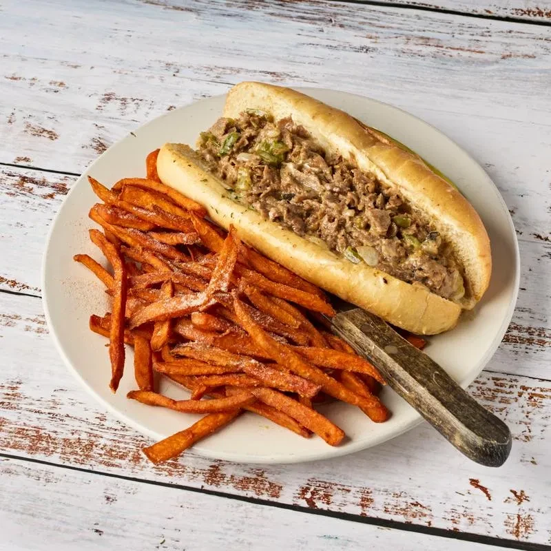 Hoagie with chopped meat, onions, green peppers, and sweet potato fries.