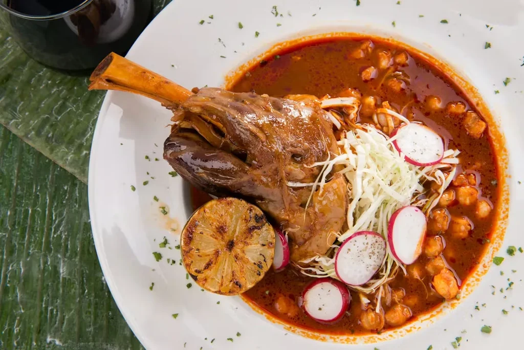 Braised lamb shank in stew with cabbage, radishes, and lime.