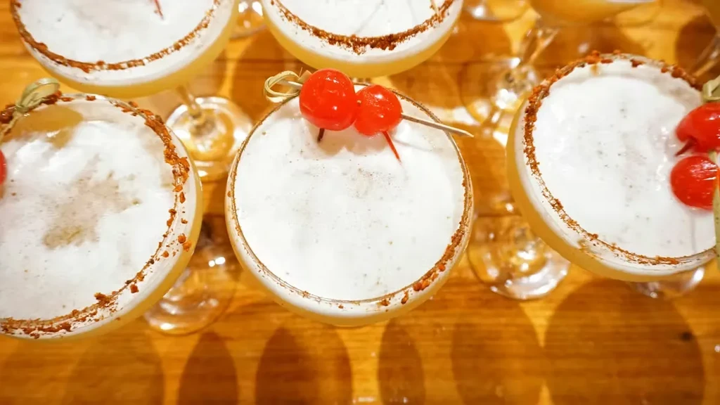 Top-down view of cocktails with foamy tops and spice-rimmed glasses.